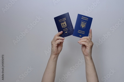 The concept of changing citizenship. Repatriation. Law of Return. Women's hands holding an Israeli passport and a Ukrainian passport on a white background photo