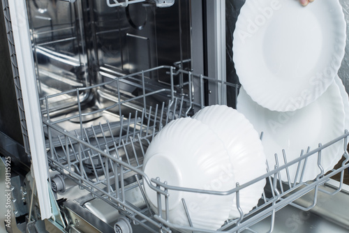 clean dishes in the dishwasher basket. Cleaning the house and washing dishes in the dishwasher.