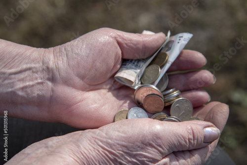 Small coins in the wrinkled hands of an elderly woman.
