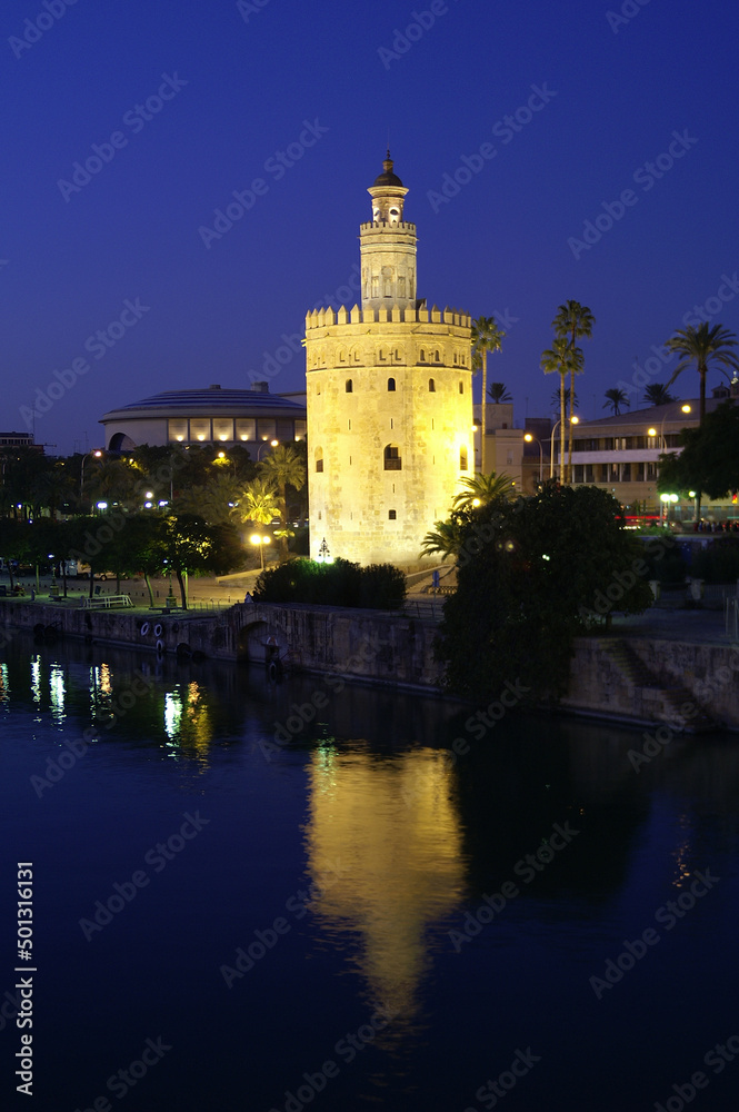 Seville (Spain). Night view of the Torre del Oro next to the Guadalquivir river in the city of Seville