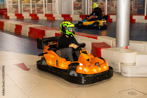 Happy girl driving a toy car. Amusement park for children