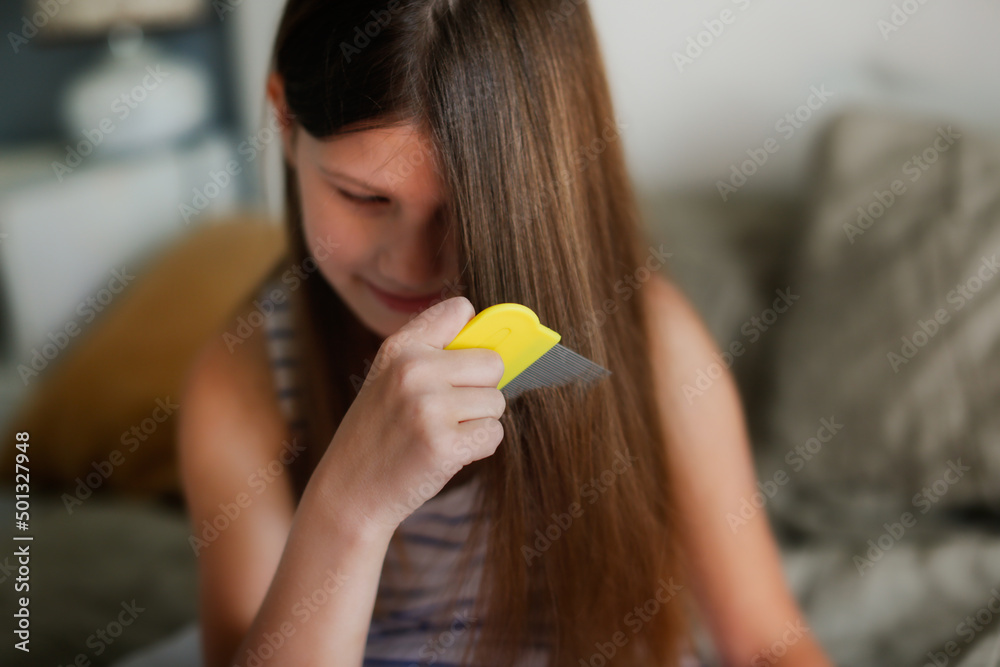 Longhaired European girl child with lice comb, protection. Health and