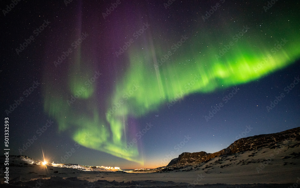 Northern lights over Sisimiut town in Greenland in winter
