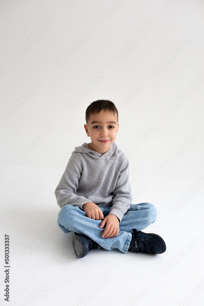 Boy child preschooler smiling and posing on gray background in photo studio Boy child preschooler smiling and posing on gray background in photo studio