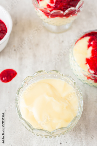 Homemade vanilla pudding with white chocolate and raspberry sauce