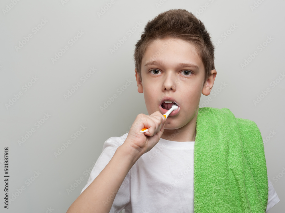The boy cleaning his teeth using a toothbrush and toothpaste. Dental and oral care The boy cleaning his teeth using a toothbrush and toothpaste. Dental and oral care