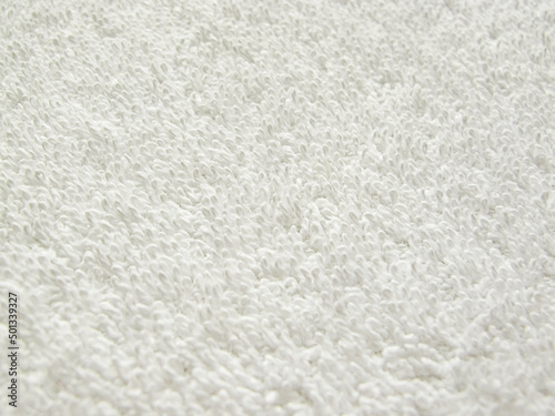 Close-up of a towel terry cloth. White fabric and texture concept. White towel macro material.