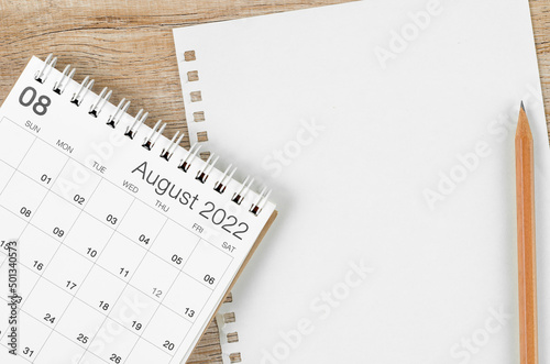 August 2022 desk calendar with blank paper sheet for your text or message on wooden background. photo