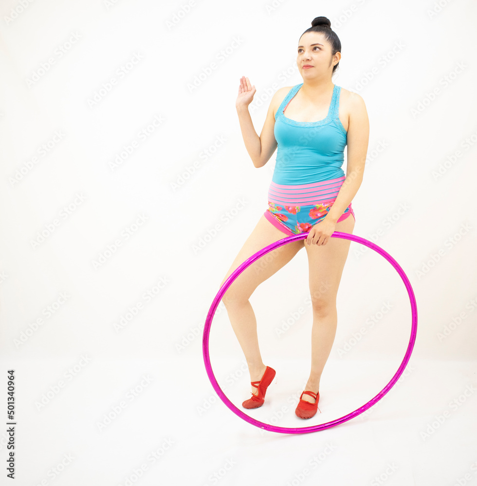 young white woman standing with hula hoop, blue blouse, short pink, with white background