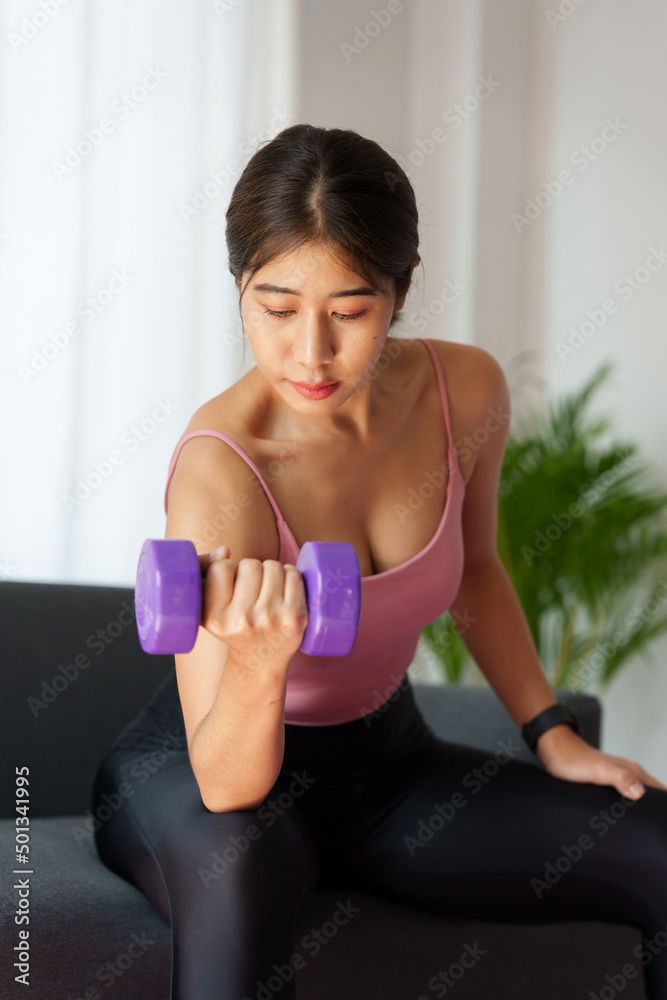 Beautiful woman exercising with dumbbells at home. bodybuilding, fitness, sport, weightlifting concept.