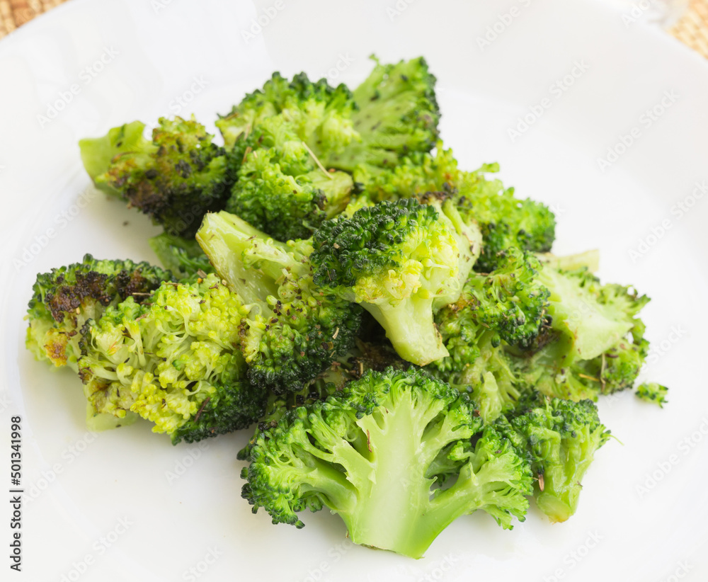 fried inflorescences of broccoli with provencal herbs on white plate fried inflorescences of broccoli with provencal herbs on white plate