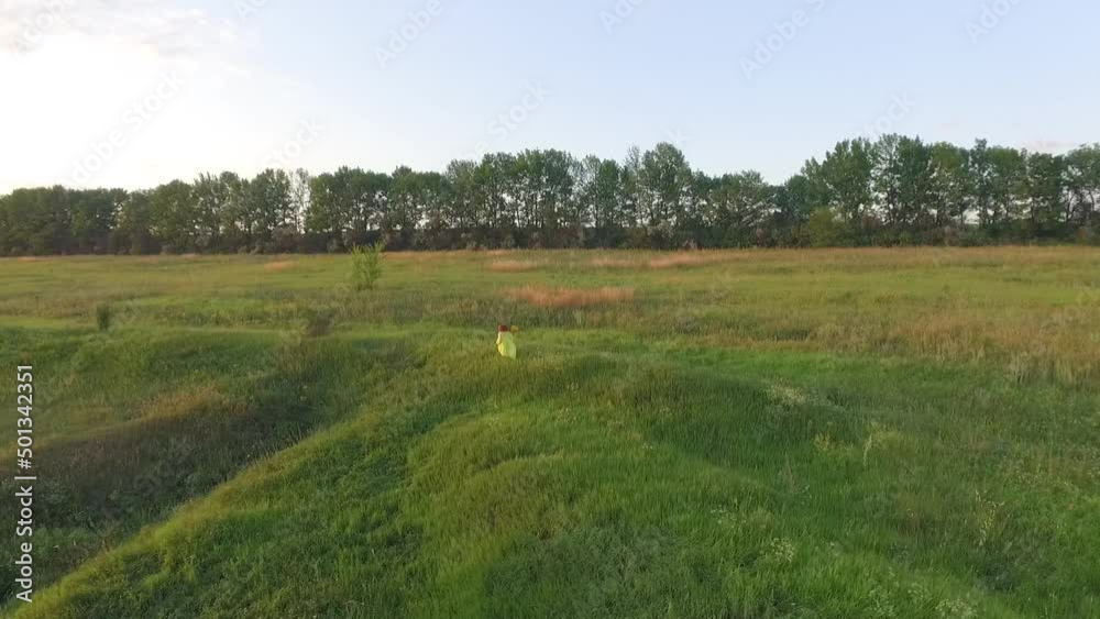 beautiful flight over a girl in a green meadow against the backdrop of sunset beautiful flight over a girl in a green meadow against the backdrop of sunset