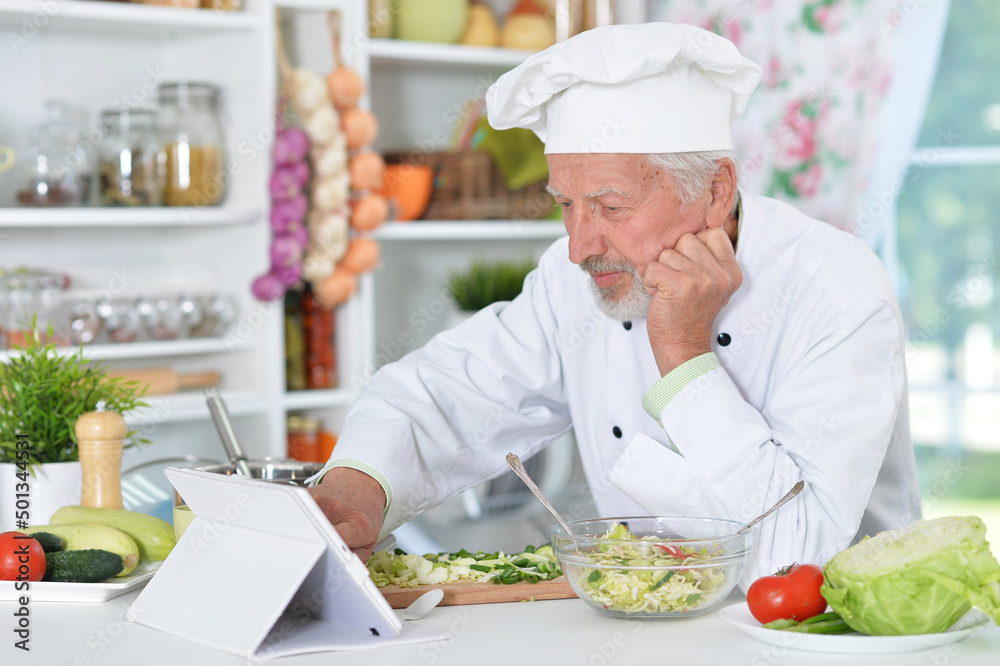 Senior man preparing dinner in kitchen Senior man preparing dinner in kitchen