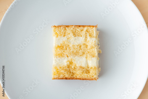 cake cut with sponge biscuit and cream cheese layers on the white background. Copy space. Flat lay