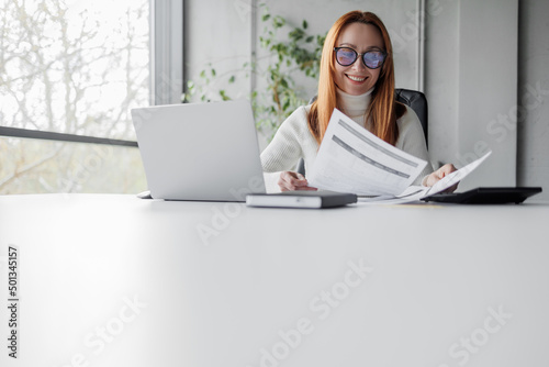 Happy mid aged business woman working with papers.