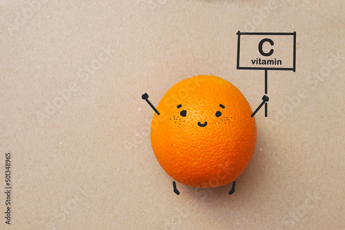An orange with a smile and with the inscription: vitamin C. Vitamin C in oranges
