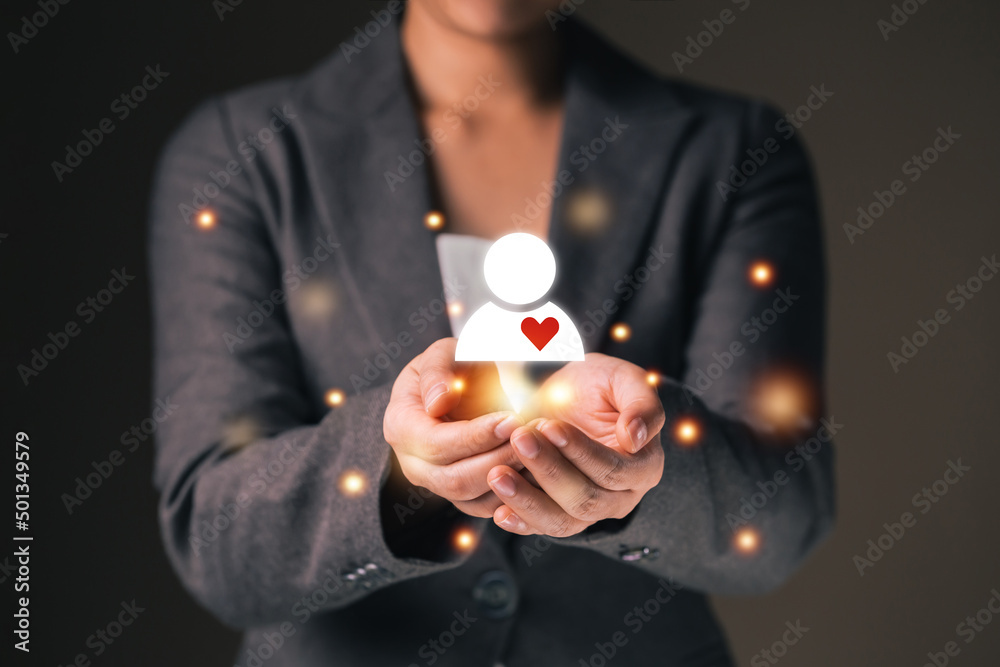 Fototapeta premium Empathy female manager holding human icon with heart shape over palm hands. Power of emotional intelligent, soft skill development concept