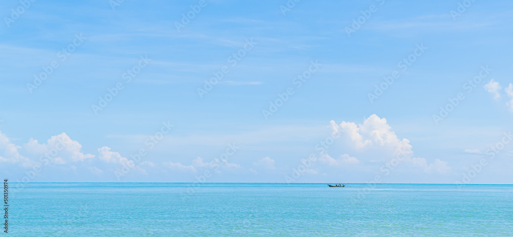Small traditional fishing boat minimal on blue sea and sky clouds in summer season 