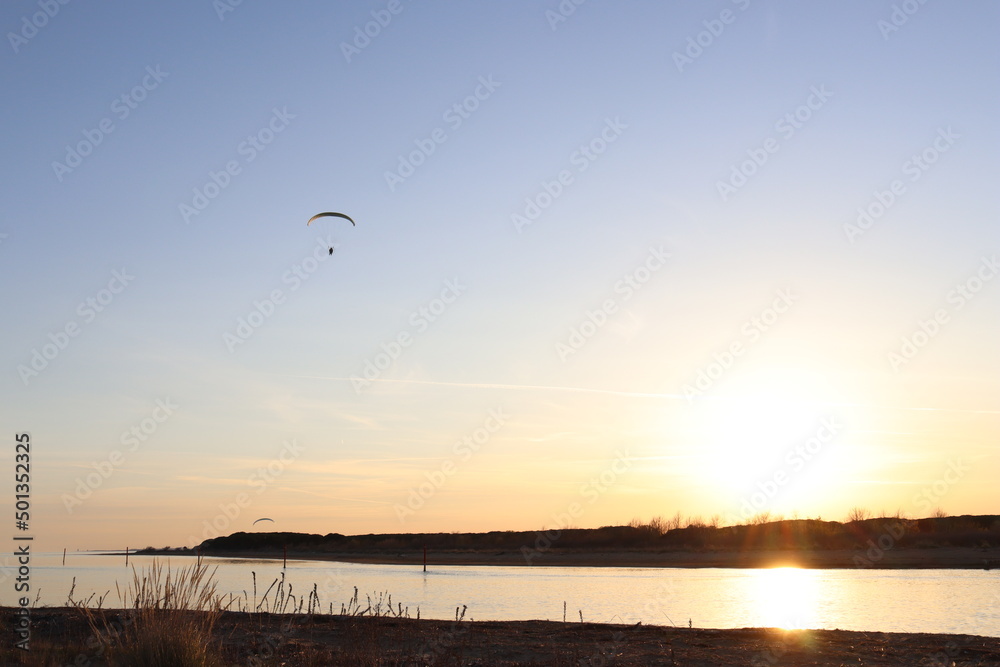 Einsamer Paragleiter fliegt in den Sonnenuntergang