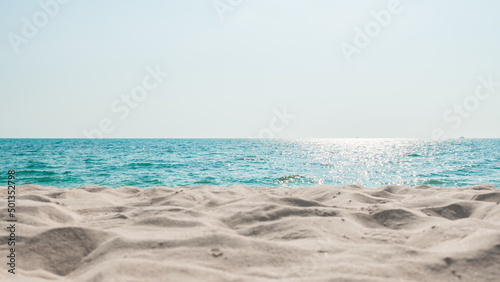 Beach sand sea water summer background. Sand beach desert texture. White foam wave sandy seashore