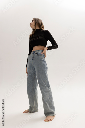 woman in trendy jeans posing on a light background