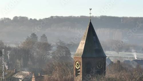 Panning flight along the tower of the church in Westouter in the Flemish province of West Flanders in Belgium photo