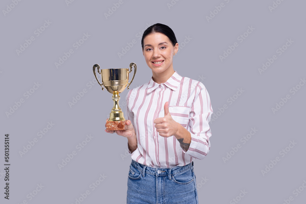 Girl Holding Trophy Showing Thumb Up Isolated. Girl Goals. Winner. Girl Smilling. Trophy in Girl Hands Girl Holding Trophy Showing Thumb Up Isolated. Girl Goals. Winner. Girl Smilling. Trophy in Girl Hands