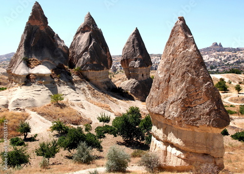 Mushroom-shaped rocks  also called the Fairy Chimneys  with caves inside close-up in the Rose Valley between the towns of Goreme and Cavusin in Cappadocia  Turkey