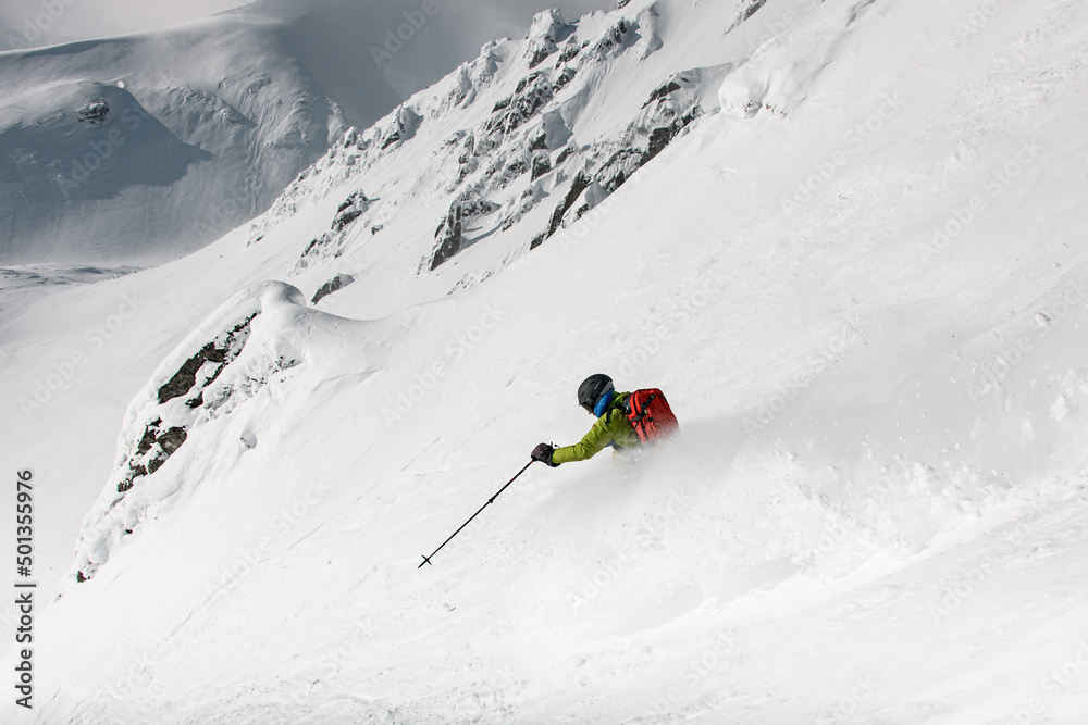 beautiful mountain slope with powder snow and skier is actively going down. Freeride skiing concept