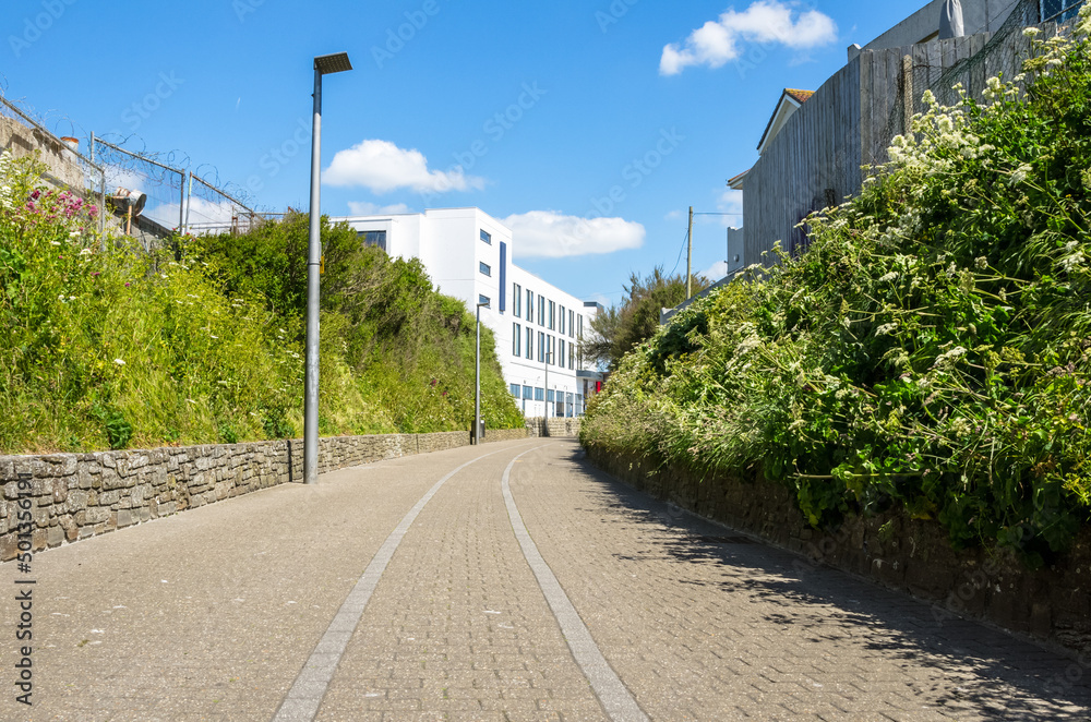 Empty cobbled path for pedestrians and cyclists lined with  lamp posts on a sunny summer day