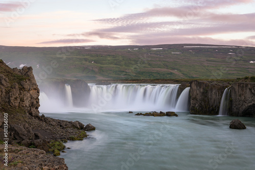 Majestic waterfall in warm midnight sun light in summer. Godafoss, Iceland.