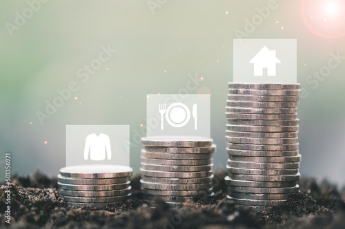 Fotografie Step of coins stacks growing with food, clothes, house, 3 necessities that human
