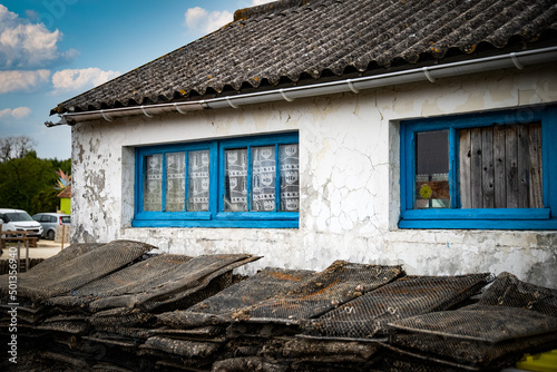 maison de pêcheur blanche avec fenêtres bleues avec poches à huitres