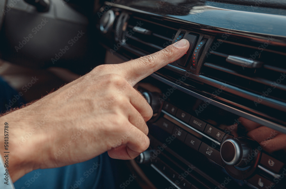 Fototapeta premium Male hand pushing button in his automobile