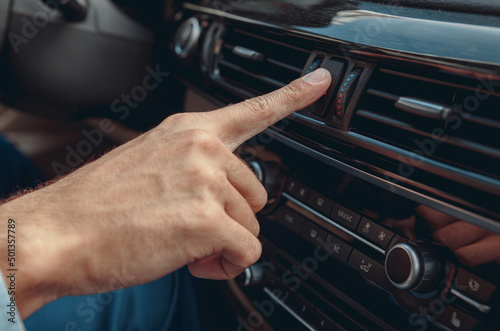 Male hand pushing button in his automobile