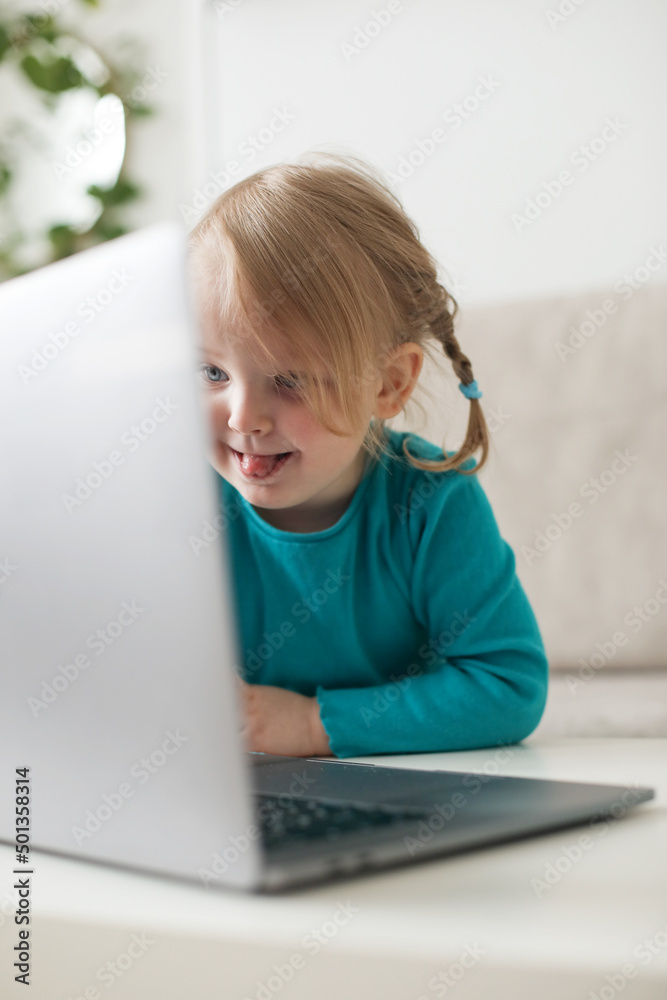 little girl uses a laptop video chat to communicate learning at home, child studying online. little girl uses a laptop video chat to communicate learning at home, child studying online.