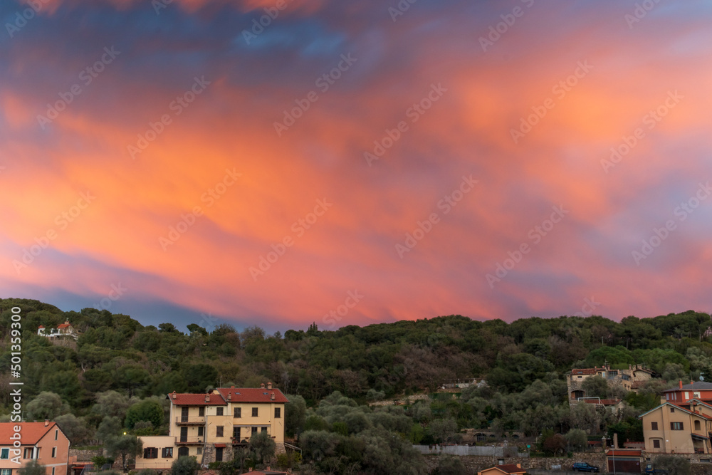 Ligurian hill with trees, houses and sunset
