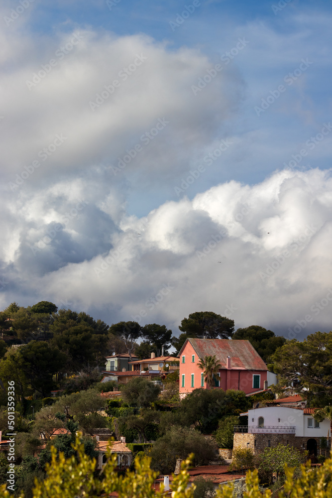 Ligurian houses on the hill with cloudy sky.