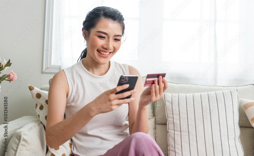 Happy asian woman using smartphone shopping online with credit card.  Lifestyle. Easy pay using smart phone or digital device.