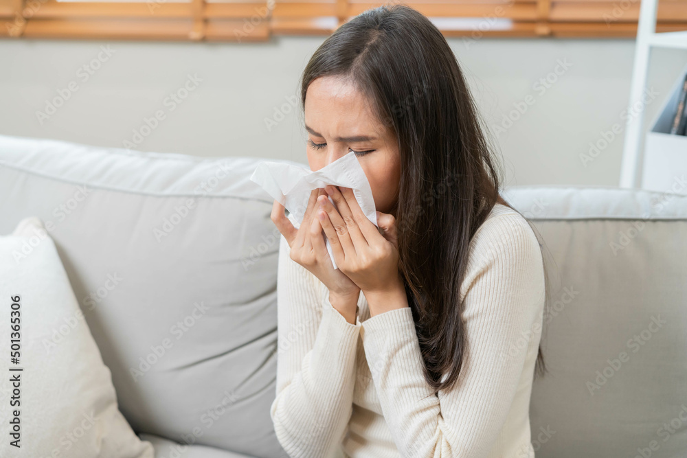 Sick, Coronavirus covid-19 asian young woman, girl headache under blanket have a fever, flu and use tissues paper sneezing nose, runny sitting on sofa bed at home. Health care on virus person. Sick, Coronavirus covid-19 asian young woman, girl headache under blanket have a fever, flu and use tissues paper sneezing nose, runny sitting on sofa bed at home. Health care on virus person.