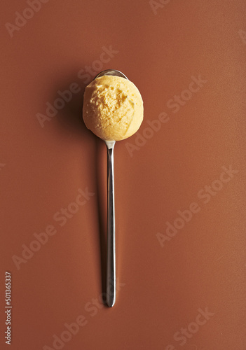 Ice cream spoon with a scoop of cream ice cream. photo