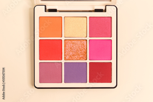 Presentation of the brand and packaging. A makeup palette floating on a white background. Professional multi-color eyeshadow palette. Cosmetic products. Close-up. View from above. Place to copy