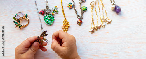 hands of child play with light summer bijouterie, on white background. concept of womens happines. High quality photo