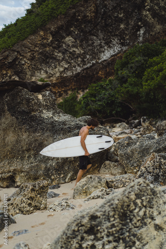 Surfboard Surfer Outdoor Sport Tropical Ocean Concept. Young handsome man with a surfboard on the ocean.