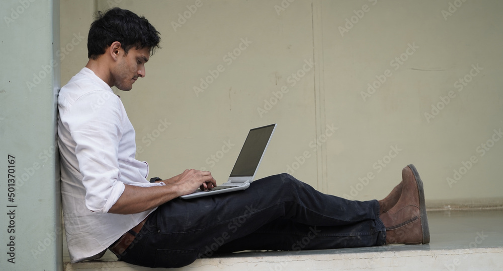 A university student is learning lessons online while sitting at the university campus