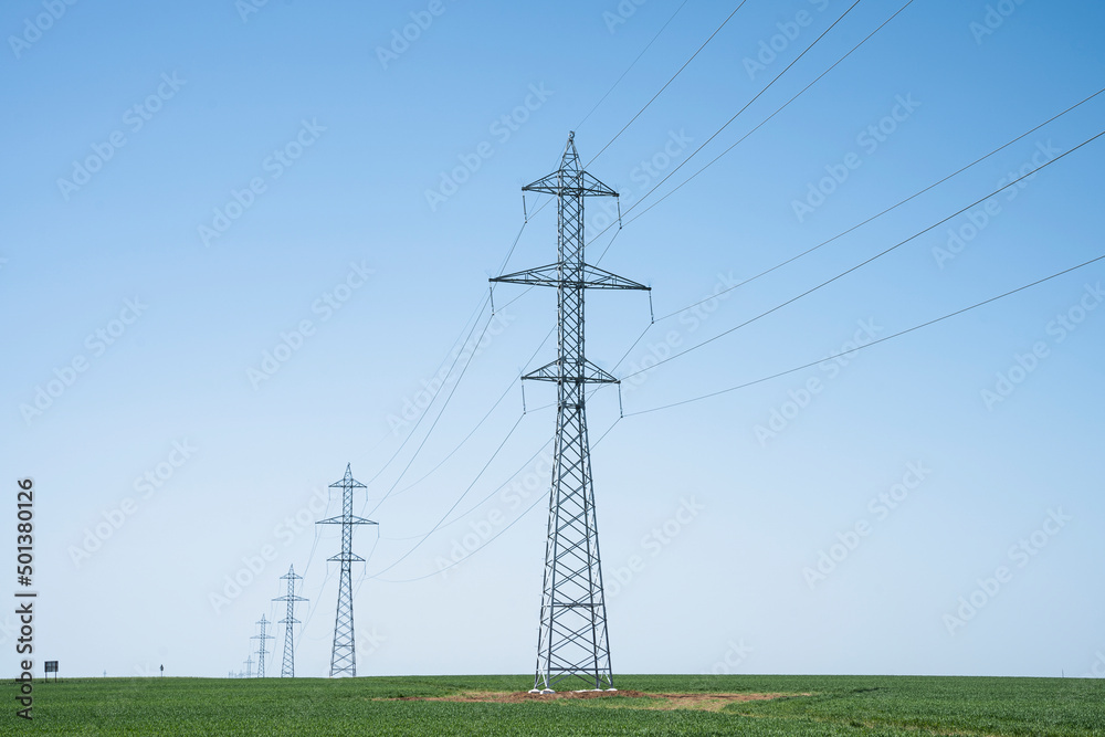 New installed barriers for electricity transmission in the meadows, blue sky in background. New installed barriers for electricity transmission in the meadows, blue sky in background.