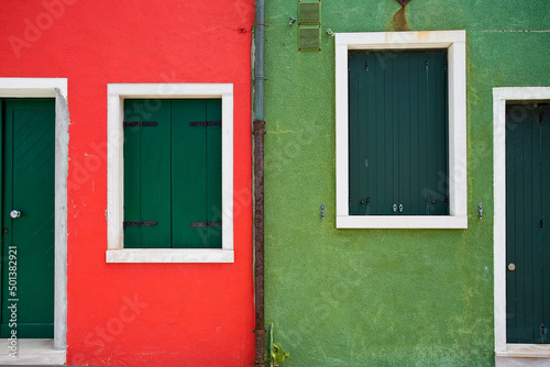 Scenic view of red and green buildings with wooden windows in Burano, Venice, Italy photo