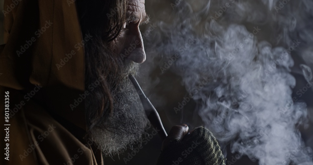 Bearded male hermit smoking pipe