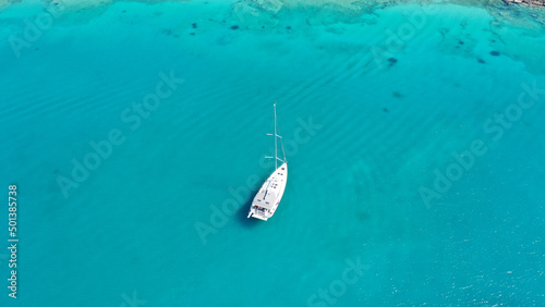 Aerial drone photo of beautiful sail boat anchored in Aegean island paradise bay with turquoise sea © aerial-drone