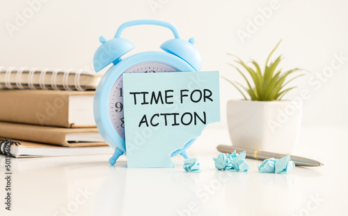 Procrastination delay and urgency concept with word Time for Action on sticky paper over white alarm clock